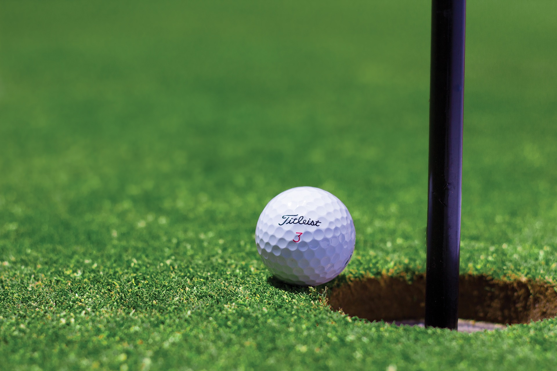 Golf ball at edge of hole